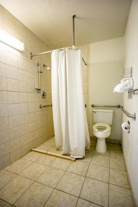 a bathroom with a white shower curtain and a toilet at Marifah Inn Sweetwater in Sweetwater