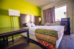 a hotel room with a bed and a desk at Marifah Inn Sweetwater in Sweetwater