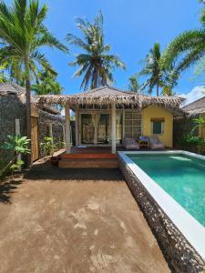 a villa with a swimming pool and a house at Bamboo Lodge 2 in Gili Trawangan