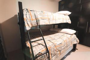 テピクにあるCasa Tacuba / Amplio Departamento moderno con terrazaのベッドルーム1室(二段ベッド1組、毛布付)