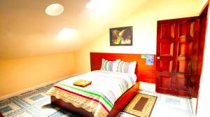 Habitación pequeña con cama y puerta abierta en Hostal History, en Quito