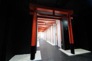 a hallway with orange and black poles in a room at Shibuya Hotel En in Tokyo