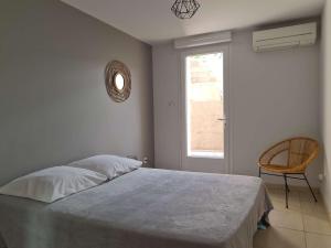 ein Schlafzimmer mit einem Bett, einem Fenster und einem Stuhl in der Unterkunft Appartement Banyuls-sur-Mer, 3 pièces, 4 personnes - FR-1-225C-95 in Banyuls-sur-Mer