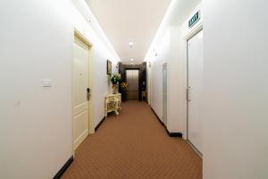 um corredor de um corredor com paredes brancas em Rosee Apartment Hotel - Luxury Apartments in Cau Giay , Ha Noi em Hanói
