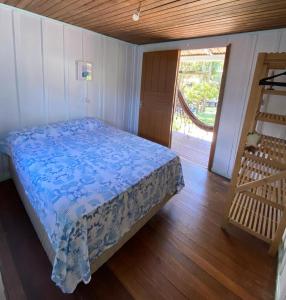 a bedroom with a bed and a wooden floor at Quartos Casa da Ilha do Mel - Nova Brasília in Ilha do Mel