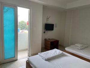 een kamer met 2 bedden, een tv en een raam bij Ky Phu in Thuan An