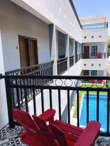 d'un balcon avec des chaises rouges et une piscine. dans l'établissement Hotel Casa Nodin, à Cuatrociénegas de Carranza