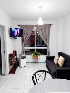sala de estar con sofá y TV en Rolgar en Mendoza
