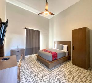 - une chambre avec un lit, une commode et une télévision dans l'établissement Hotel Casa Nodin, à Cuatrociénegas de Carranza
