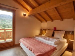 sypialnia z łóżkiem i dużym oknem w obiekcie Duplex 2 chambres avec grande terrasse, animaux acceptés, à Samoëns - FR-1-642-77 w mieście Samoëns