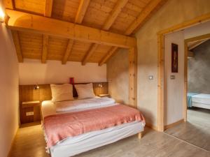 sypialnia z łóżkiem w pokoju z drewnianym sufitem w obiekcie Duplex 2 chambres avec grande terrasse, animaux acceptés, à Samoëns - FR-1-642-77 w mieście Samoëns