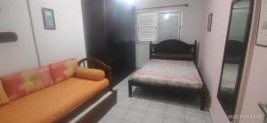 a small room with a couch and a small chair at Apartamento Espaçoso Perto da Praia in Caraguatatuba +17 photos