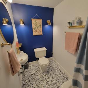 Baño azul con aseo y lavamanos en Art and Lodging, en South Bend