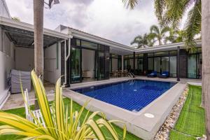 an exterior view of a villa with a swimming pool at 3 Bedroom Pool Villa BL2 in Hua Hin