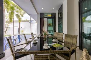 a dining room with a table and chairs on a balcony at 3 Bedroom Pool Villa BL2 in Hua Hin