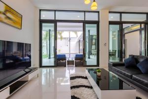 a living room with a couch and a tv at 3 Bedroom Pool Villa BL2 in Hua Hin