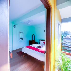 una camera da letto con un letto con pareti blu e una finestra di Hotel Elite Pokhara a Pokhara