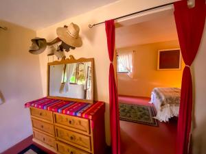 a bedroom with a dresser and a mirror at Rancho Parralito 