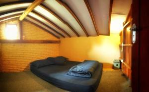 Bett in einem Zimmer mit Ziegelwand in der Unterkunft Avrila Ijen Guest House in Licin