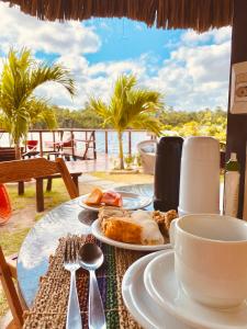 a table with a plate of food and a cup of coffee at Pousada Do Porto in Barreirinhas