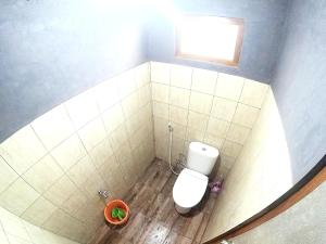 Elle comprend une petite salle de bains pourvue de toilettes et d'une fenêtre. dans l'établissement Degolan Wooden House, à Ngemplak