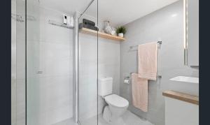 a bathroom with a shower and a toilet and a sink at Mandolin Resort in Alexandra Headland