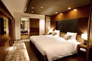 a bedroom with a large white bed in a room at Kyoto Brighton Hotel in Kyoto