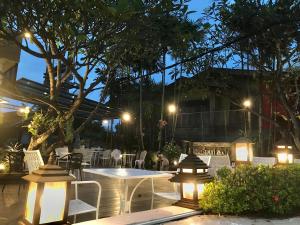 a patio with a table and chairs at night at Regent Lodge Lampang in Lampang