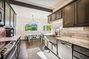 a kitchen with wooden cabinets and a dining table at Luxury River Home - Pets Stay Free in Monte Rio