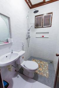 a white bathroom with a toilet and a sink at Moon's house LuangPrabang in Luang Prabang