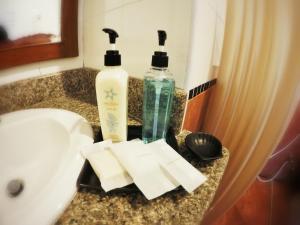 2 botellas de jabón en el lavabo del baño en Sea Front Home Hotel - Patong Beach, en Patong Beach
