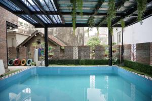 an indoor swimming pool with a pergola and blue water at Private room in Halong center-Almor Homestay in Ha Long