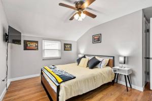 a bedroom with a bed with a ceiling fan at Spacious Home, 15min from Downtown, Private Garage & Patio in Pittsburgh