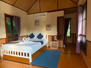 Pura Vida Pai Resort في باي: غرفة نوم بسرير ابيض في غرفة