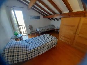 1 dormitorio en el ático con cama y ventana en Artzamendi, LA RHUNE, 4 Chambres 155 m2, en Ustaritz