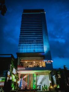 un edificio alto con luces azules encima en JLE'S Hotel, en Manado