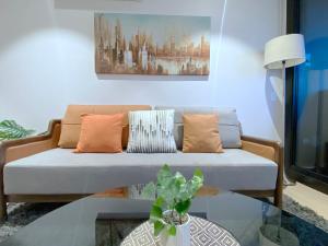 a living room with a couch and a glass table at Box Hill Central Sky One Apartment in Box Hill