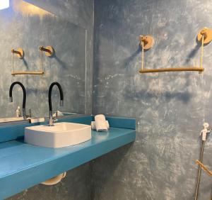 a bathroom with a sink and a blue counter at Pousada La Grécia in Camocim
