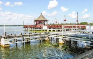 a pier with a gazebo and ducks on the water at Apartment Beautiful in Ostróda
