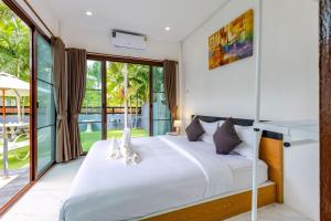 ein Schlafzimmer mit einem Bett und einem großen Fenster in der Unterkunft 4 Bedroom Modern Pool Villa BL10 in Hua Hin + 94 Fotos