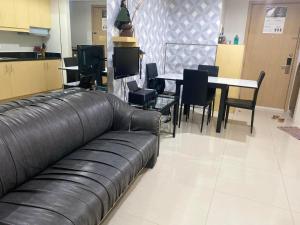 a leather couch in a room with a table and chairs at Jeffrey Paradero - Fern Residence Tower 4 in Manila