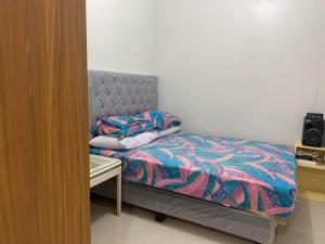 een kleine slaapkamer met een bed en een bureau bij Jeffrey Paradero - Fern Residence Tower 4 in Manilla