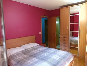 a bedroom with a bed and a purple wall at La Terraza de Zahara in Pamplona