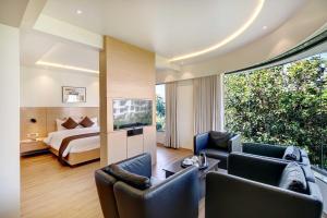 een hotelkamer met een bed en een woonkamer bij Hotel Mumbai House Ghansoli, Navi Mumbai in Navi Mumbai
