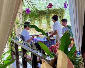 un grupo de hombres sentados en una mesa en un jardín en Pura Vida Pai Resort, en Pai