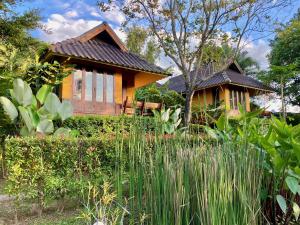 Pura Vida Pai Resort في باي: منزل أمامه حديقة