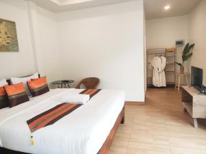 a bedroom with a large bed and a television at Himaphan Boutique Resort - SHA EXTRA PLUS in Nai Yang Beach