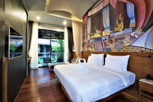 a bedroom with a large white bed in a room at Sawasdee Village in Kata Beach