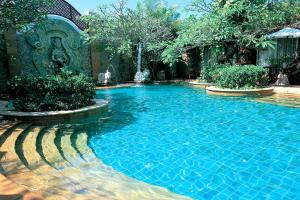 a swimming pool with blue water in a yard at Sawasdee Village in Kata Beach