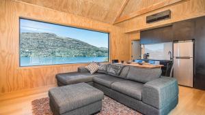 a living room with a couch and a kitchen at Picture Perfect - Queenstown Holiday Home in Queenstown